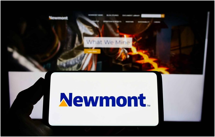 a hand holding a phone with a screen in the background