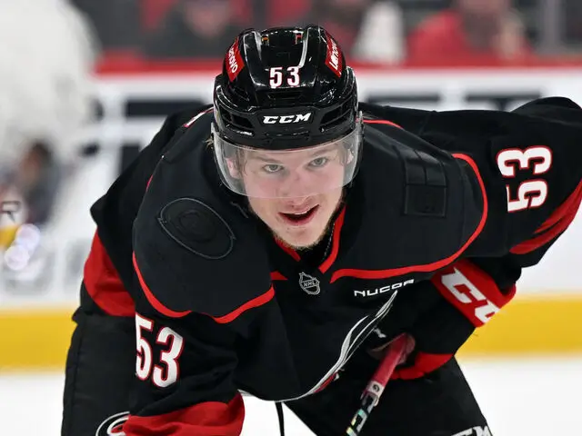 a hockey player in a black and red uniform